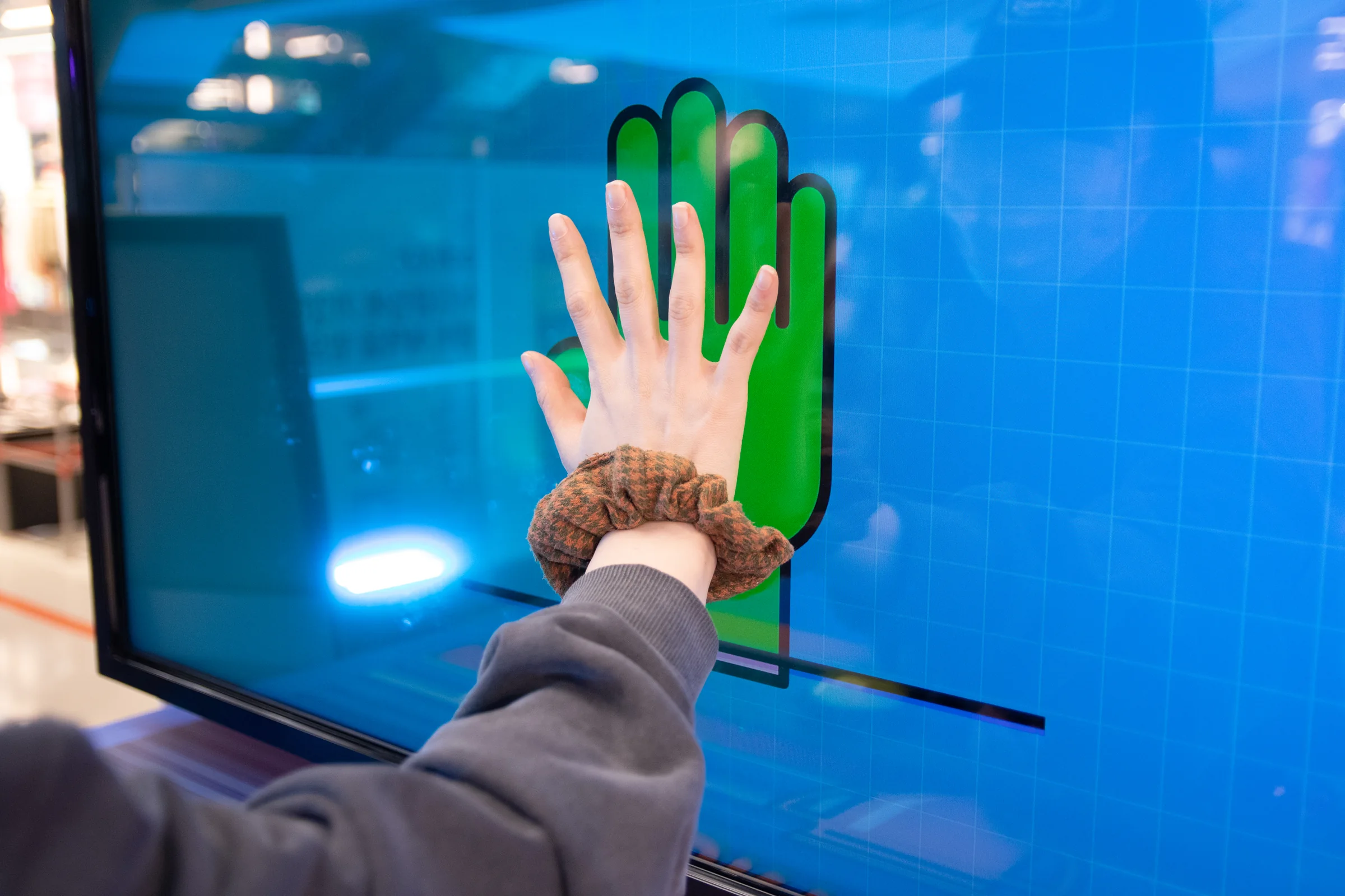 A participant aligns their palm with the green hand symbol.