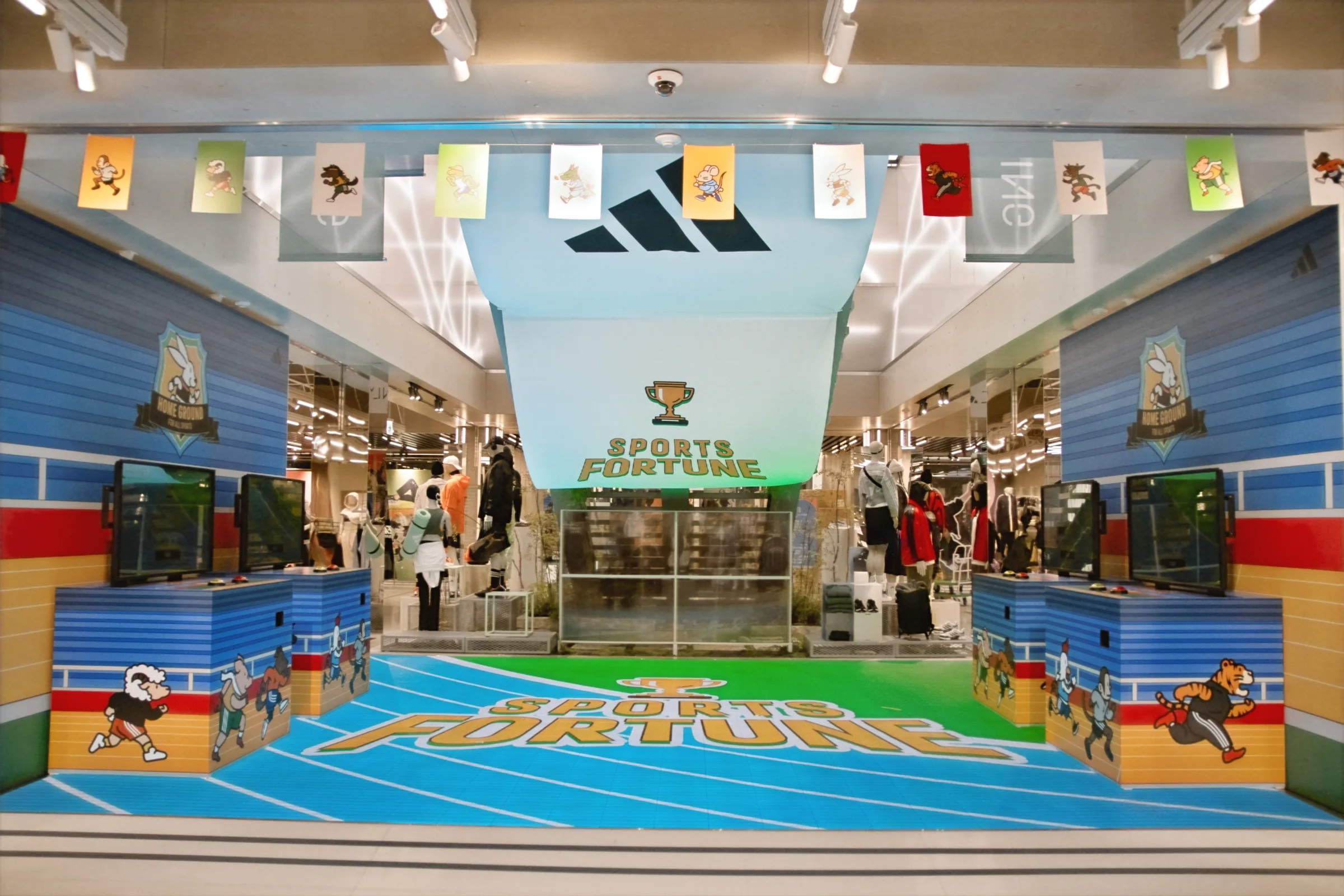 Two arcade machines stand along each graphic wall on the first floor, with SPORTS FORTUNE on the LED floor between them and zodiac character flags overhead.
