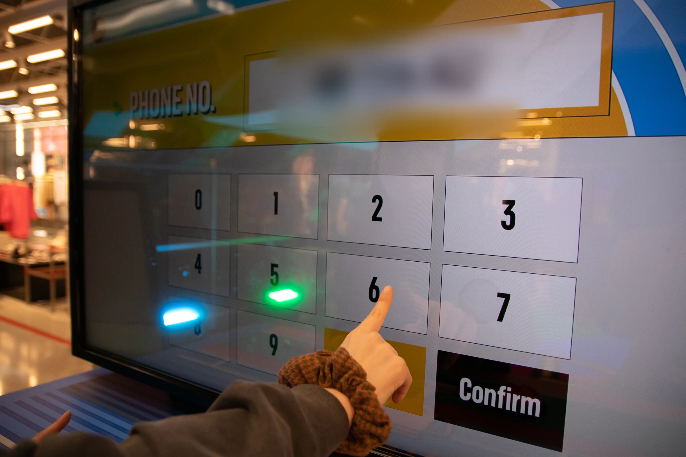 A hand enters a phone number on the numeric keypad.