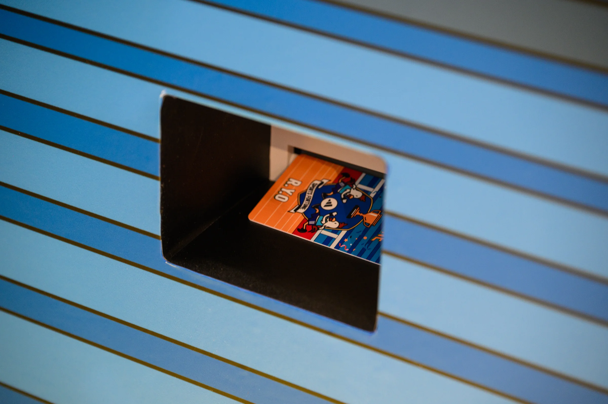 A fortune card emerges from a blue-striped arcade machine.
