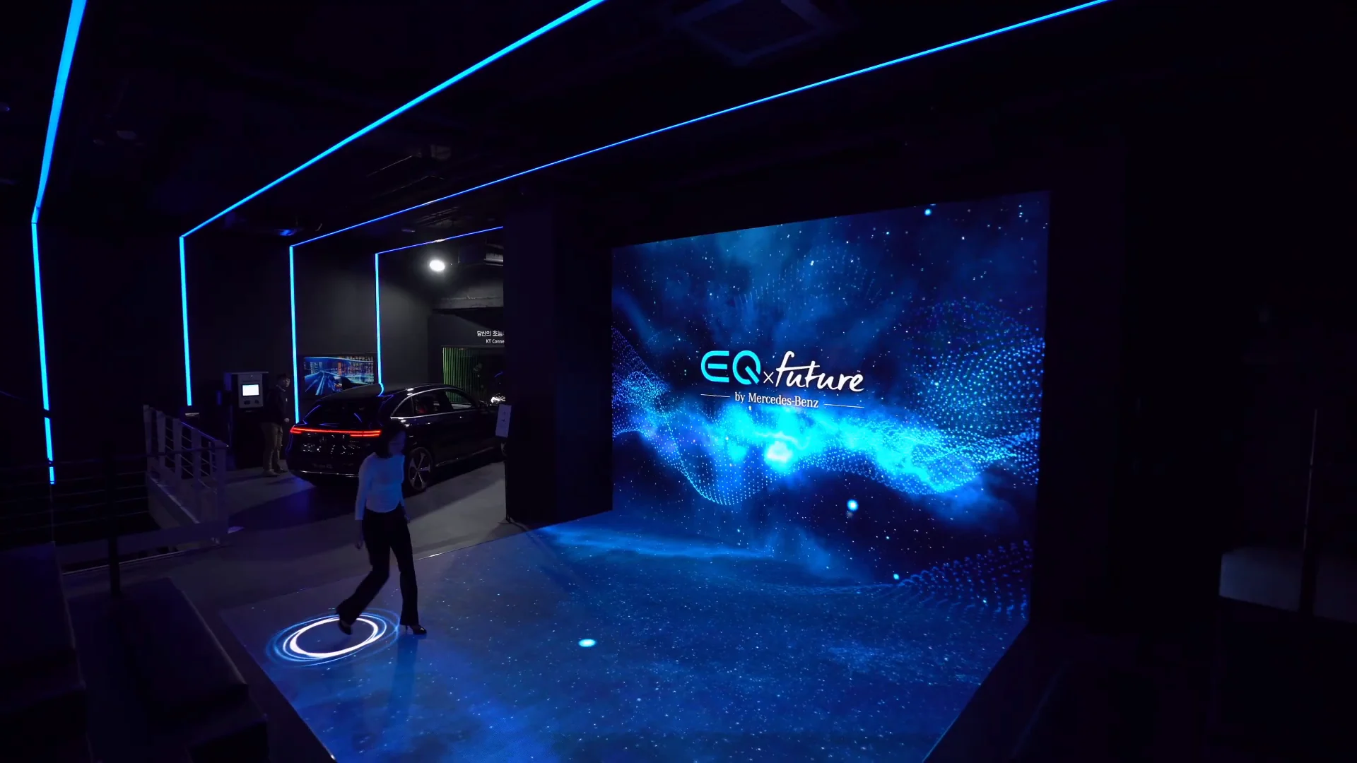 A visitor walking before the LED wall, drawing circles of light on the floor