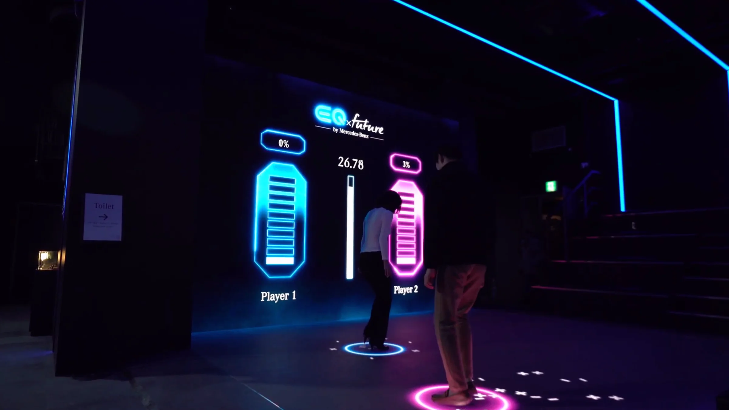 Two battery gauges on the front LED wall and two players on blue and pink floor circles