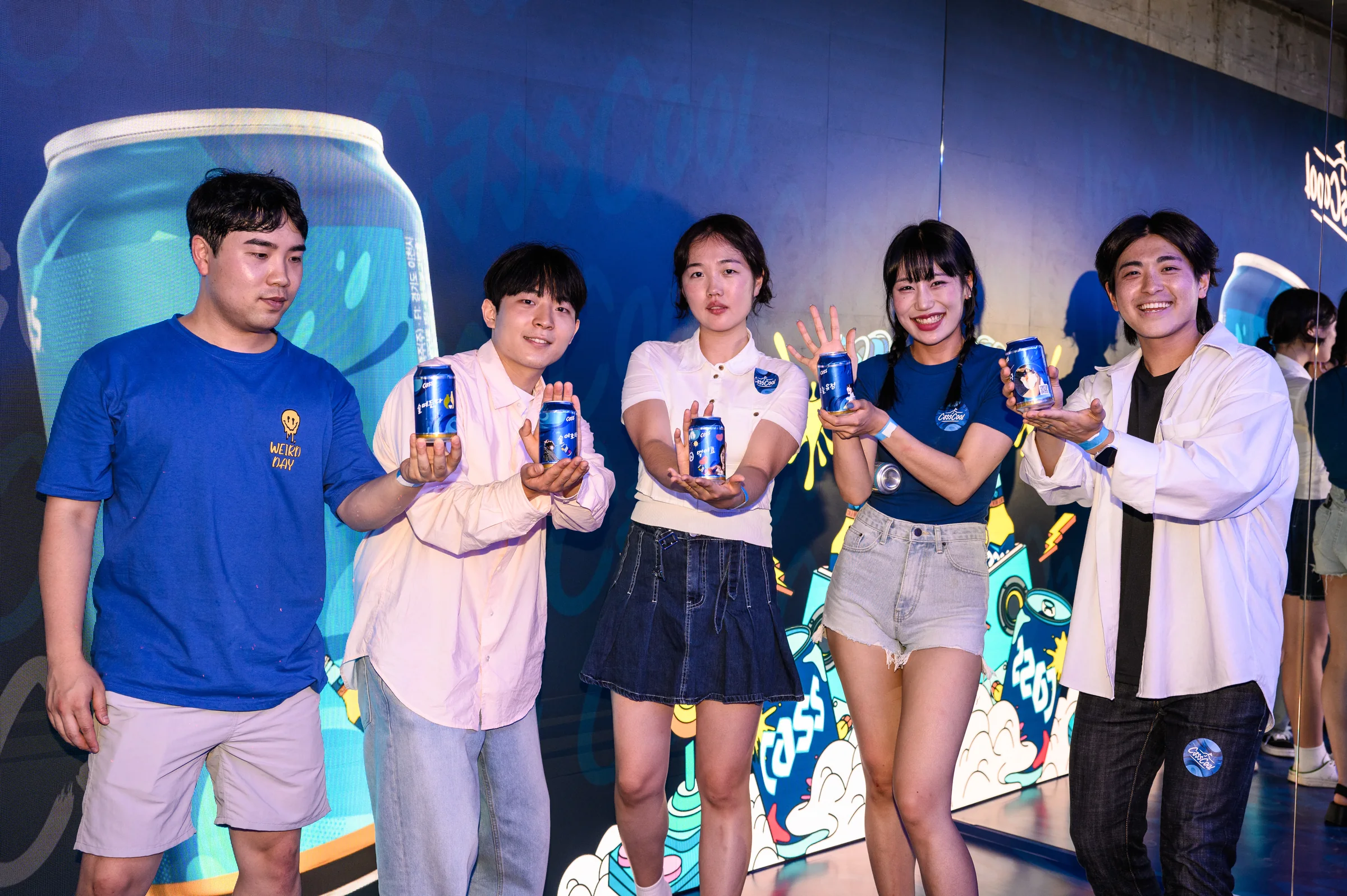 LED 앞에 모여 캔을 들고 단체 사진을 찍는 관람객들