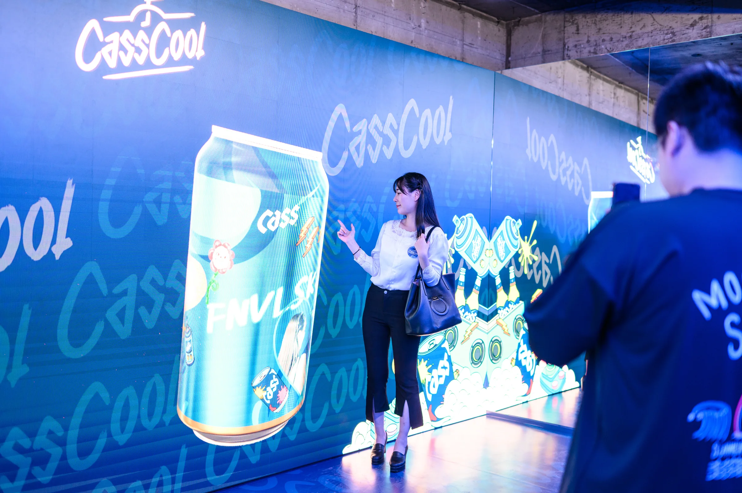 LED 벽의 거대한 캔 앞에서 사진을 찍는 관람객들
