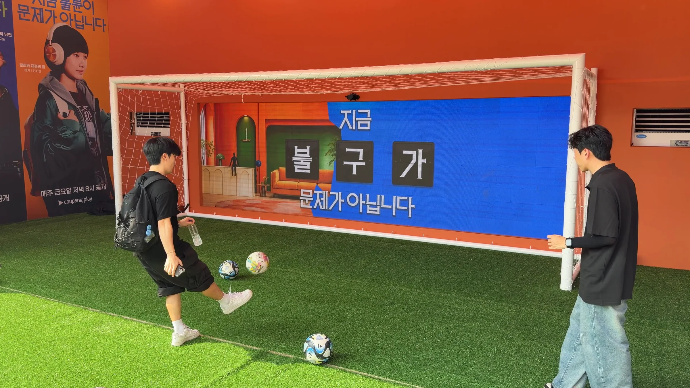 왼쪽에 세트가 드러난 화면 앞에서 참가자가 다시 공을 찬다.