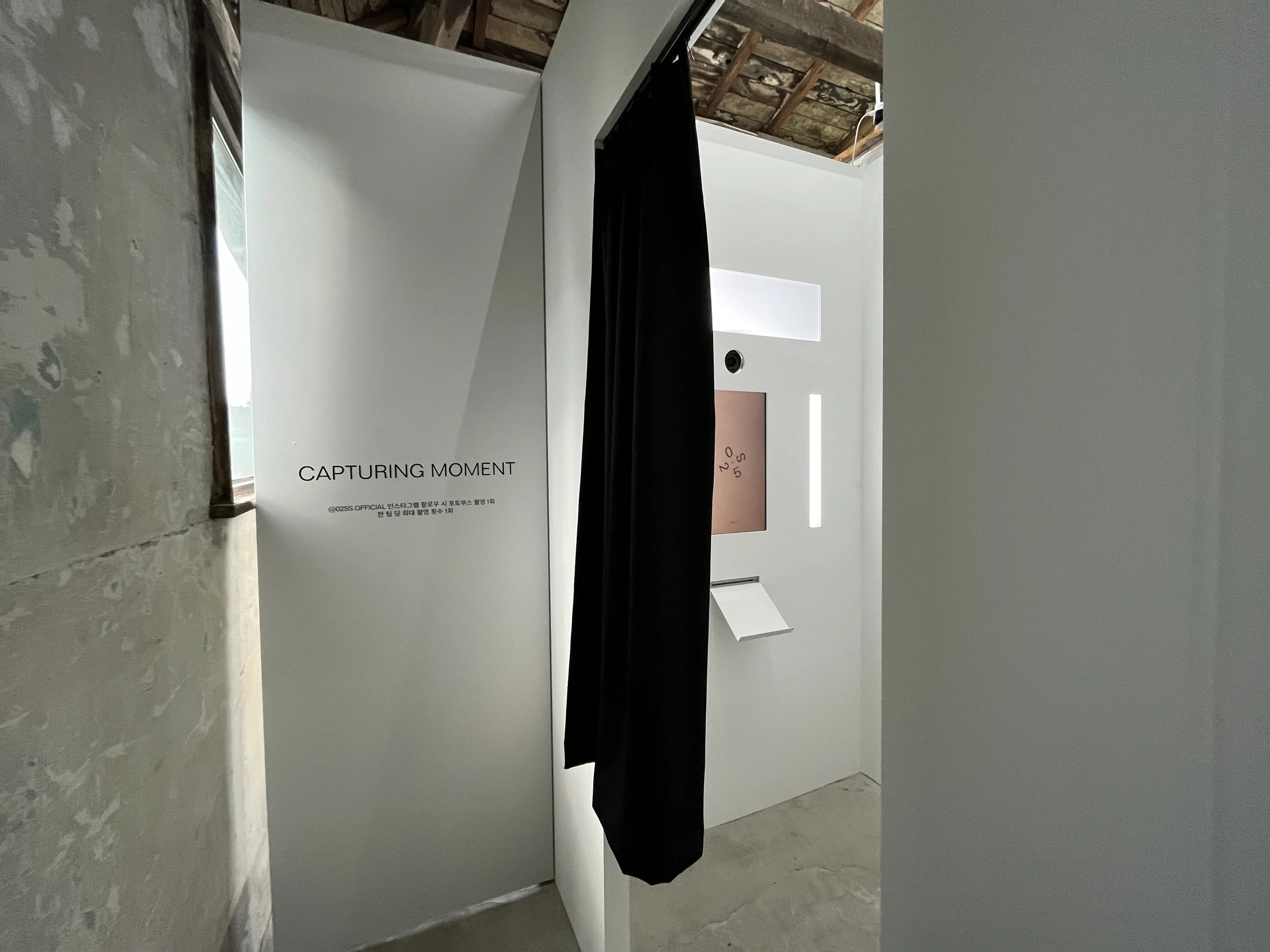 The booth entrance with its curtain open and CAPTURING MOMENT sign
