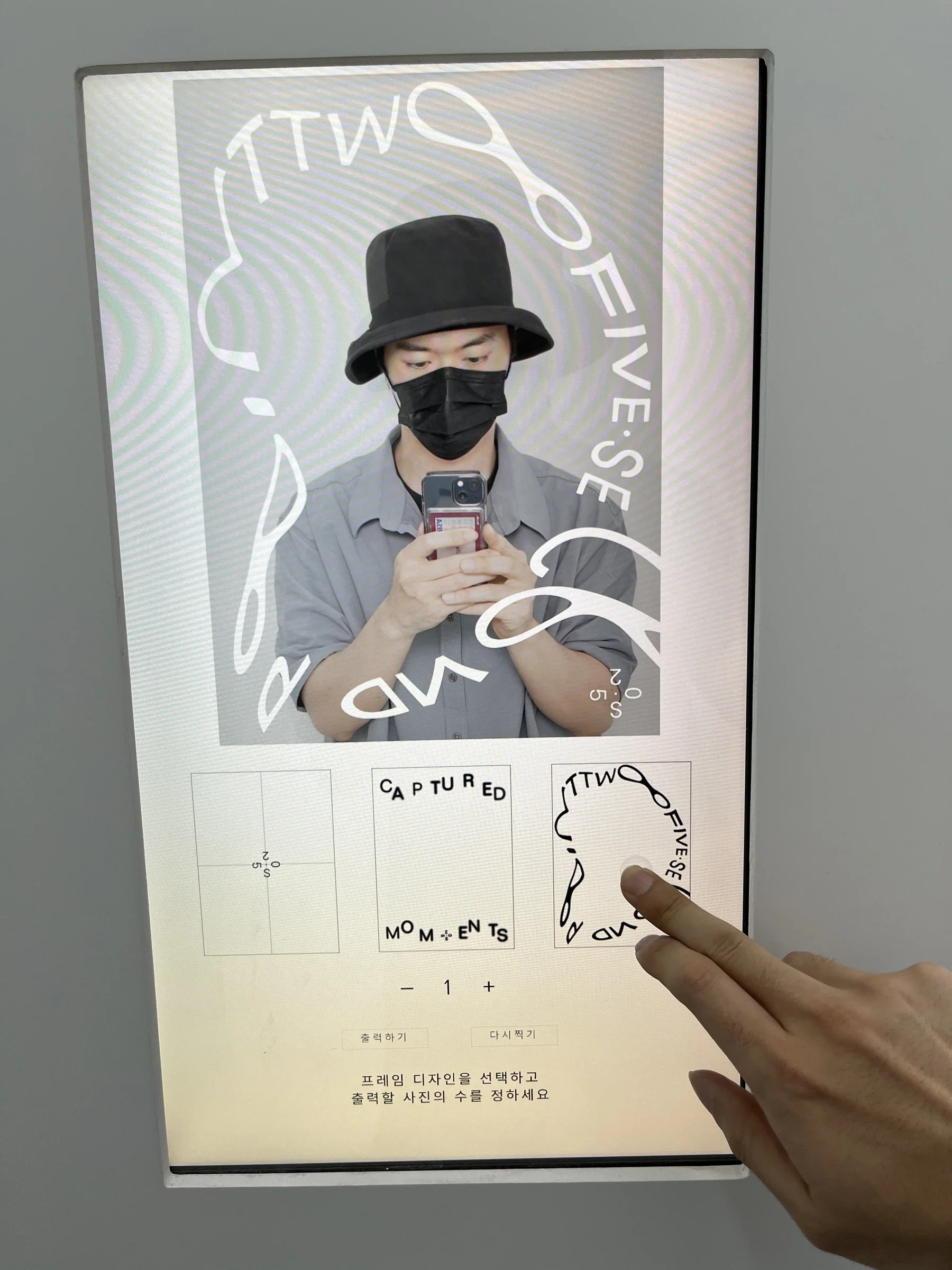 A finger selects a frame on the portrait screen.