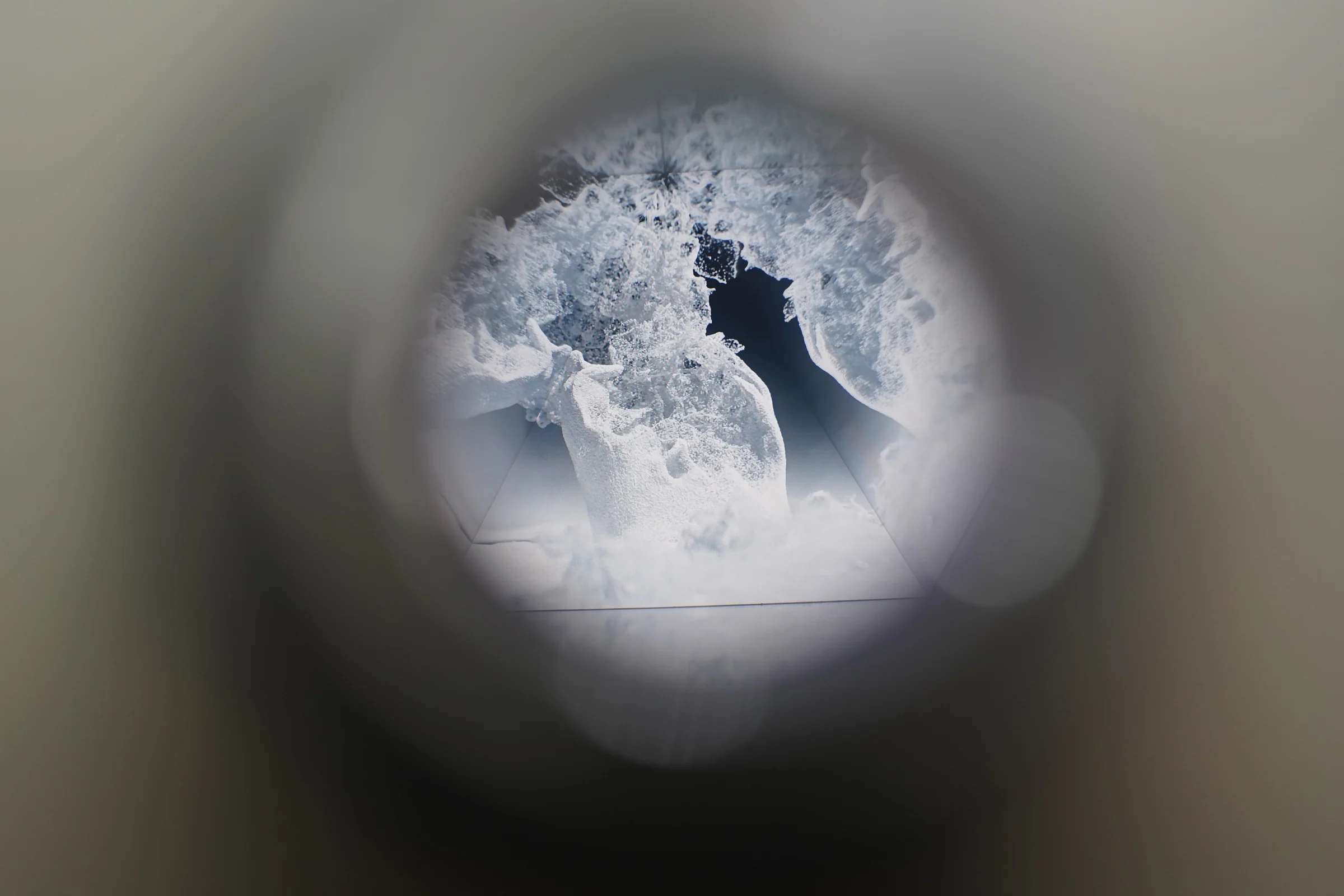 White crystals appear within the circular view through the opening.