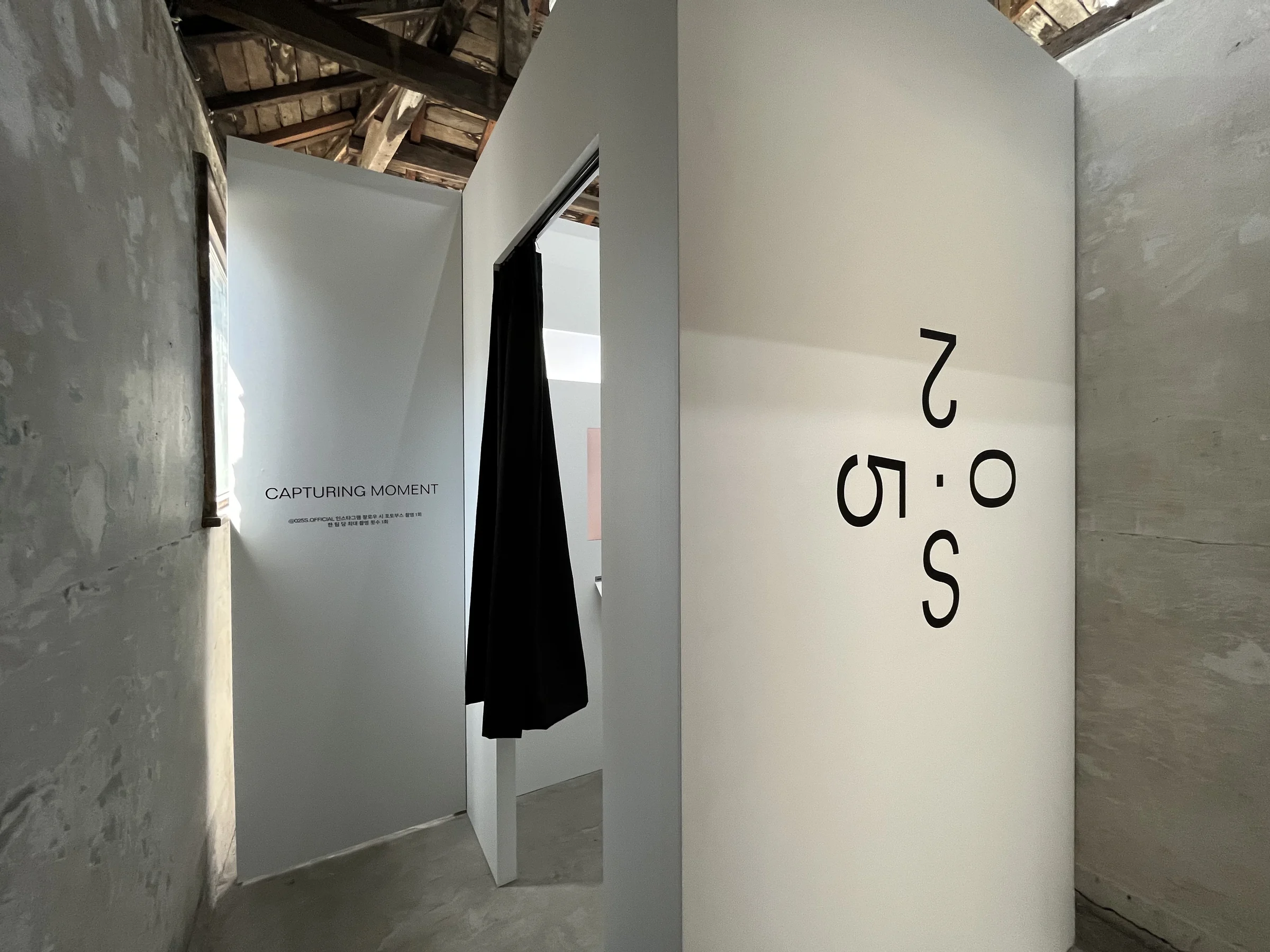 Photo booth exterior with a large 025S logo and curtained entrance