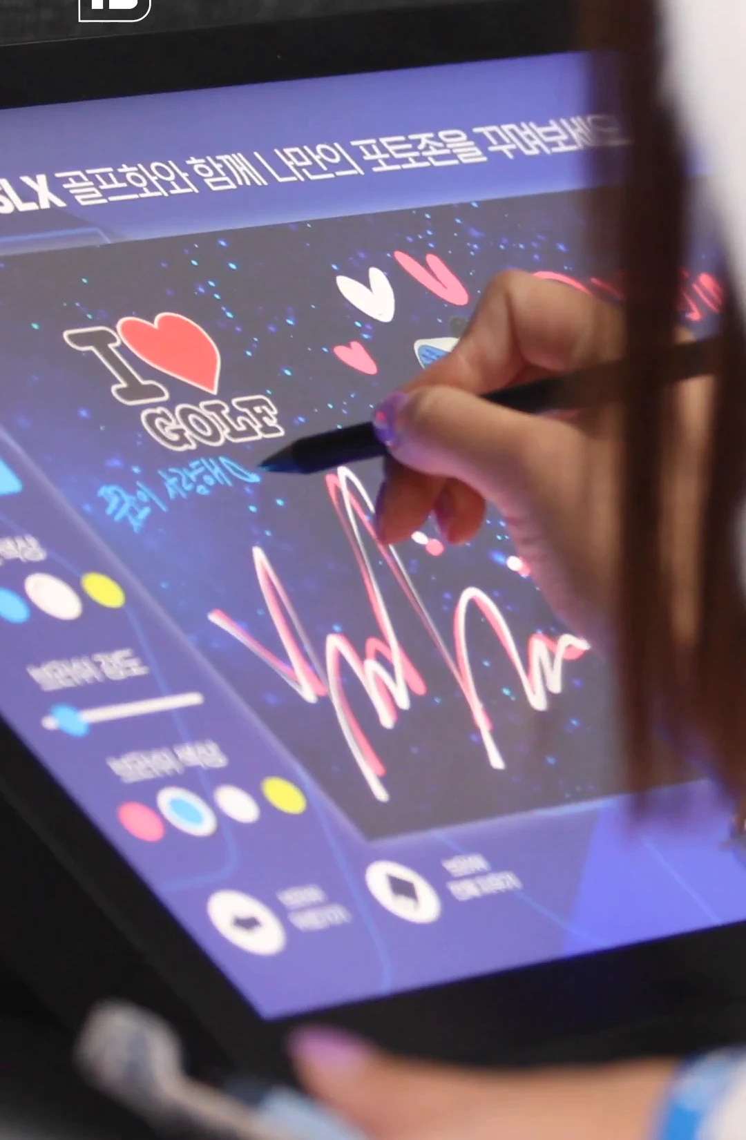 タブレットのI♥GOLFステッカーと手書き文字にペンを当てる手。