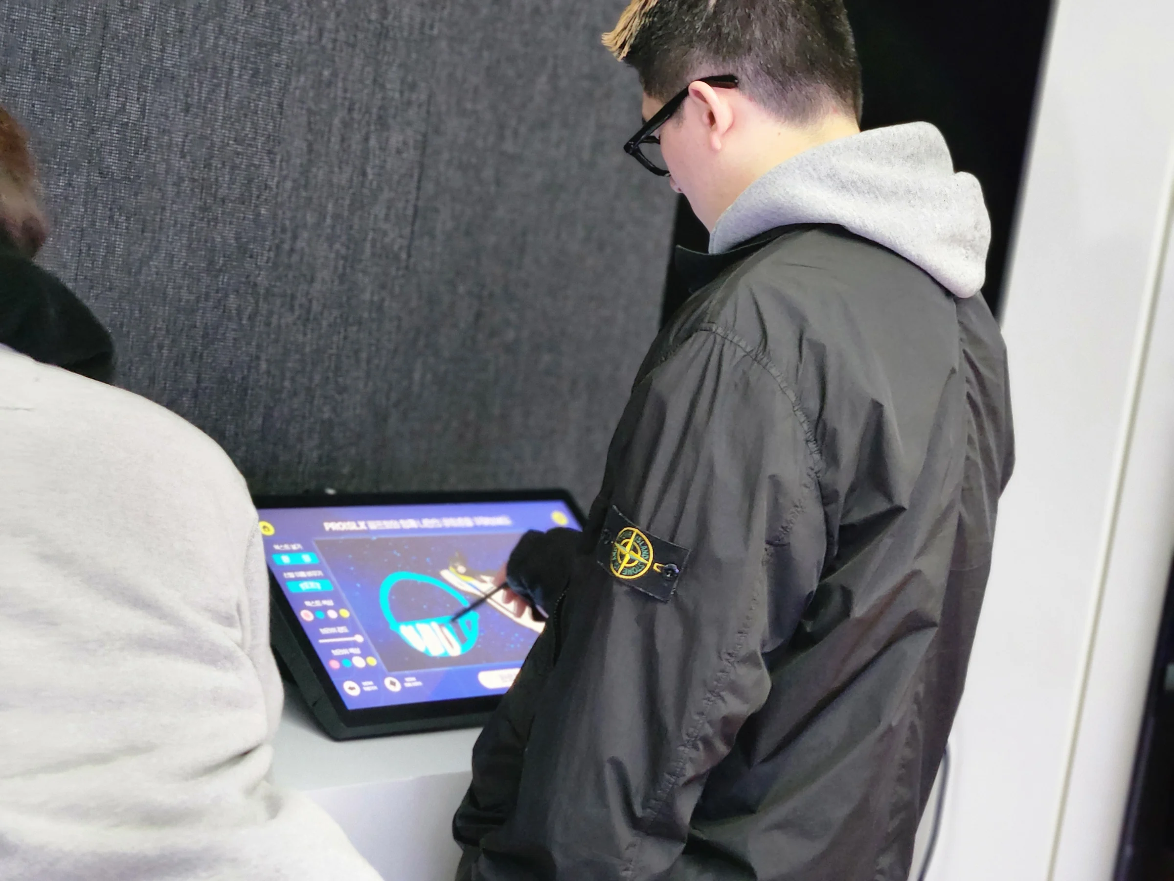 タブレットにペンで絵を描く参加者。