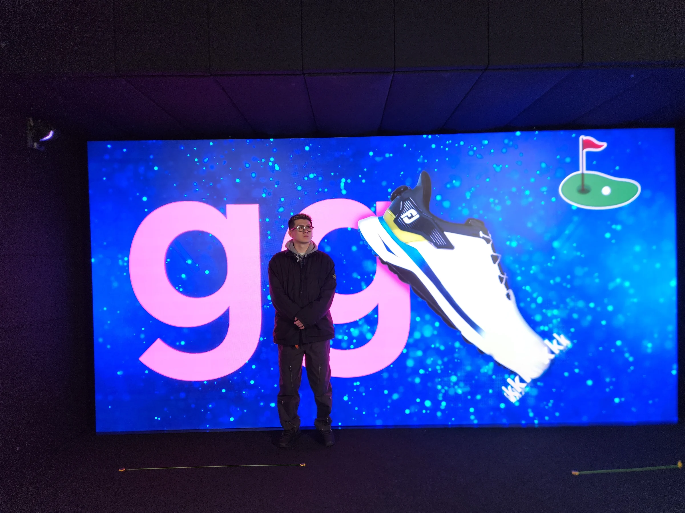 昼のテスト。大きな「go」の文字と靴が映るLEDウォールの前に立つ人。