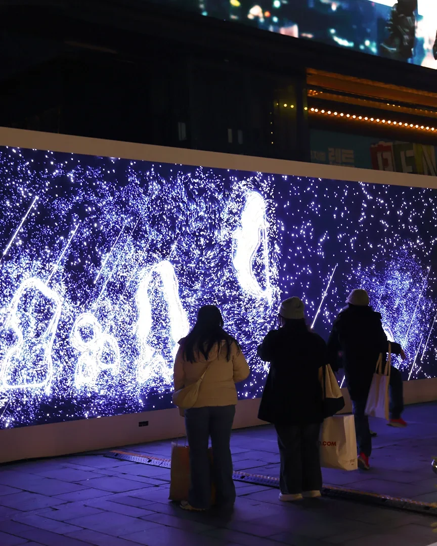 밤의 VISUAL WALL과 그 앞의 관객들