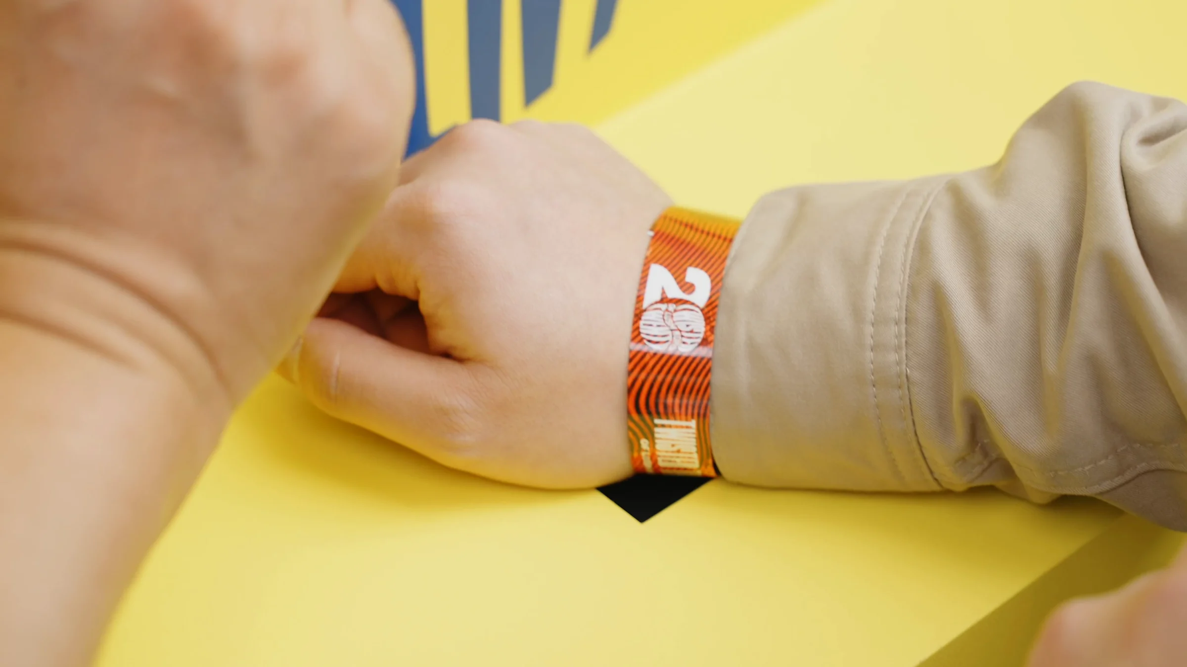 20주년 로고가 찍힌 RFID 팔찌를 찬 손목