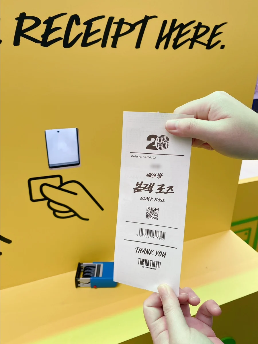 RECEIPT HERE 스캐너 앞에서 블랙 로즈 영수증을 든 손