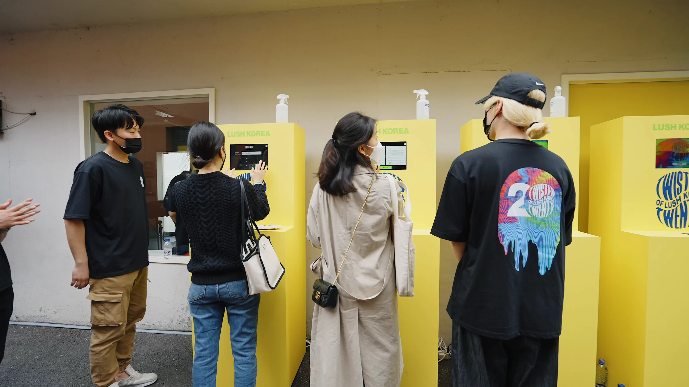 입구 마당의 노란 등록 키오스크 앞에 선 방문객들