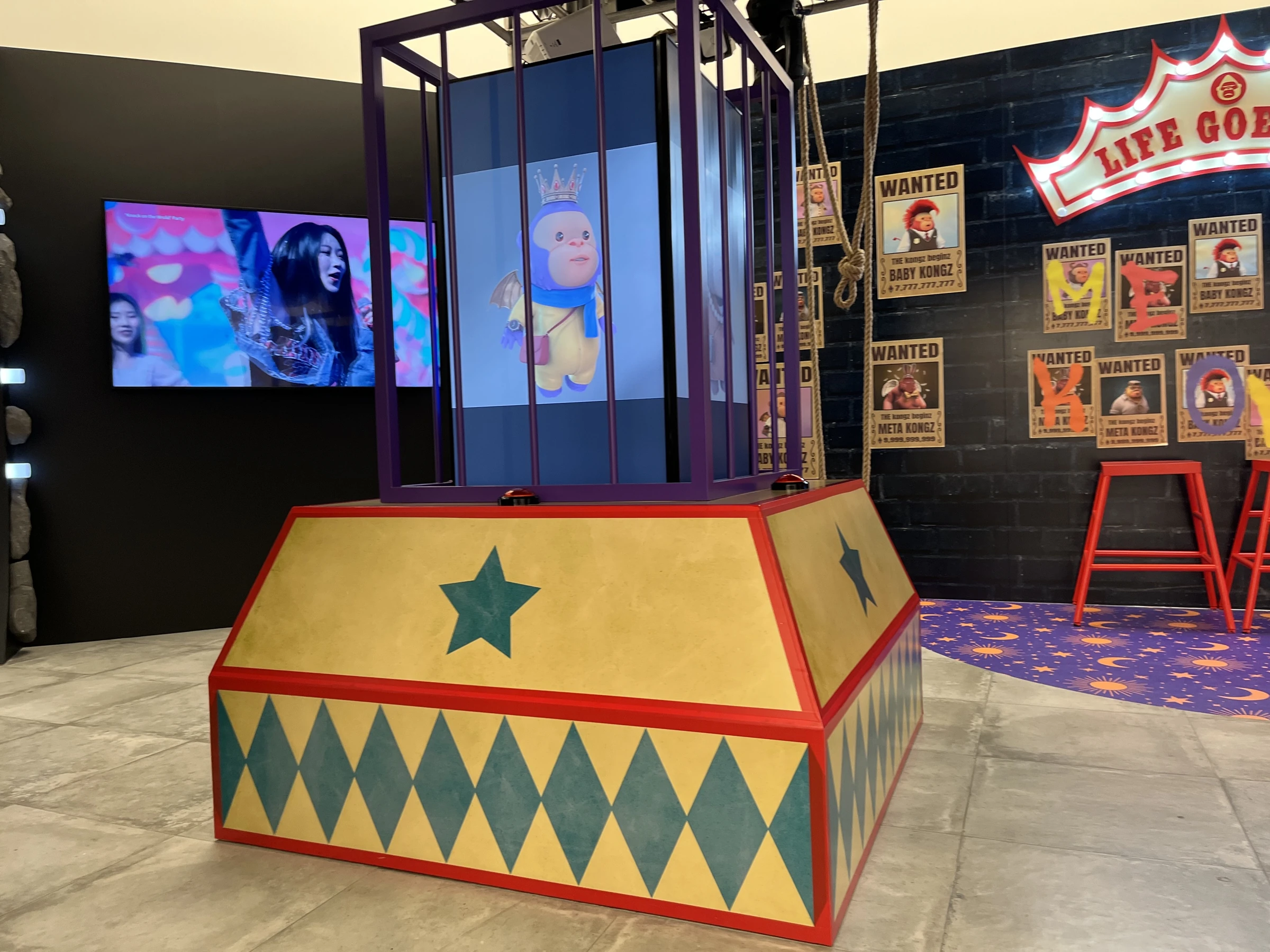 The exhibition device viewed from different angles, with artwork and a button