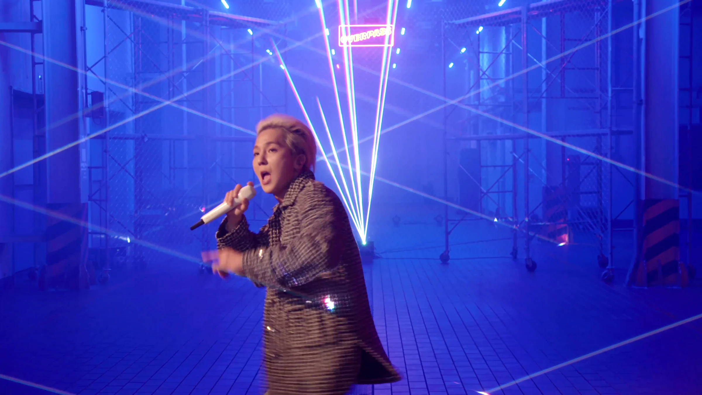 MINO under beams pouring into the blue-lit warehouse
