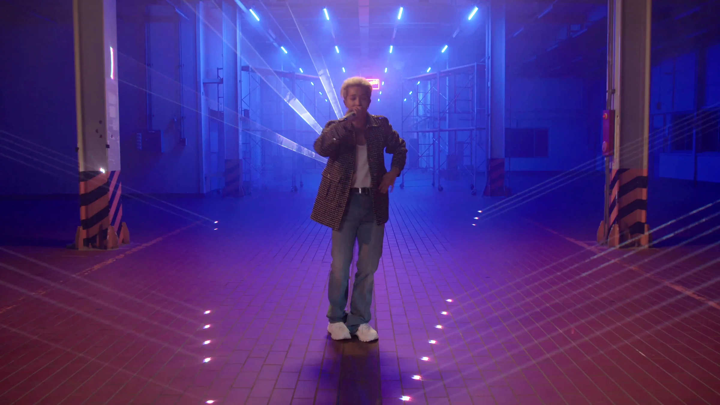 MINO at the center of the blue-lit warehouse