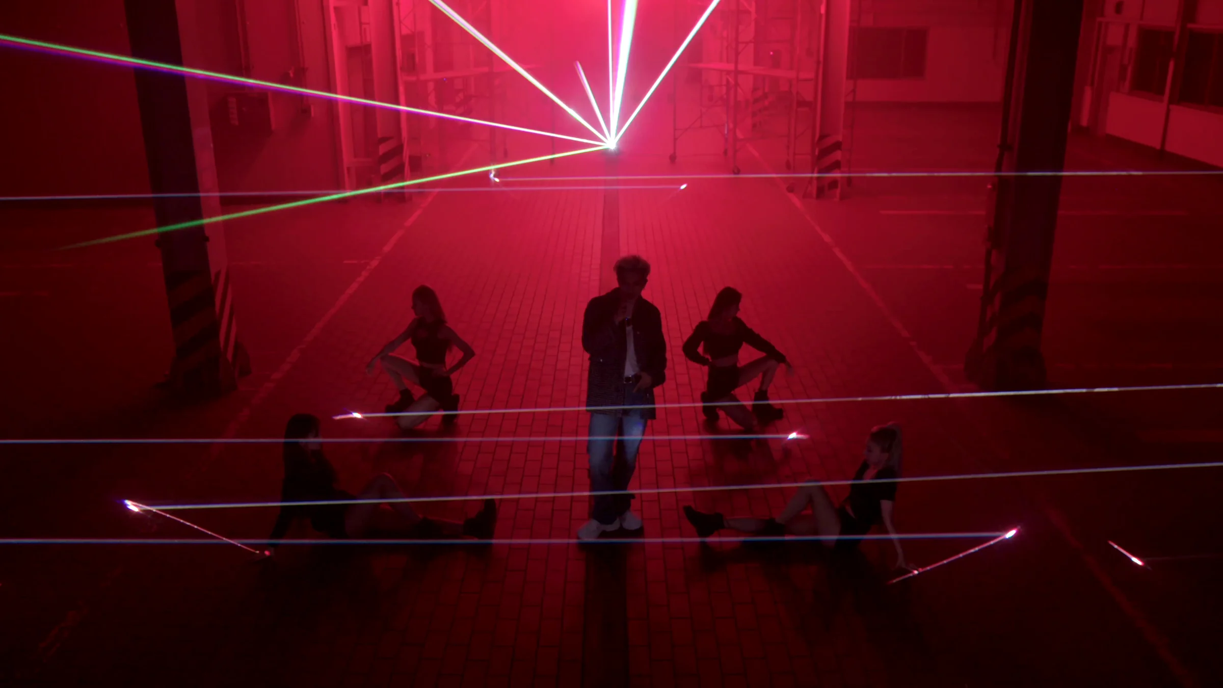 MINO and dancers in the warehouse among crossing red beams