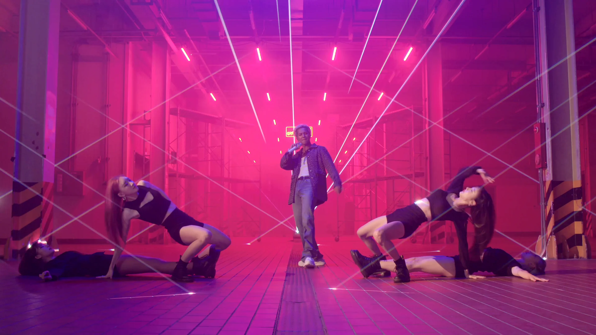 Dancers lying on the floor beneath cascading pink beams