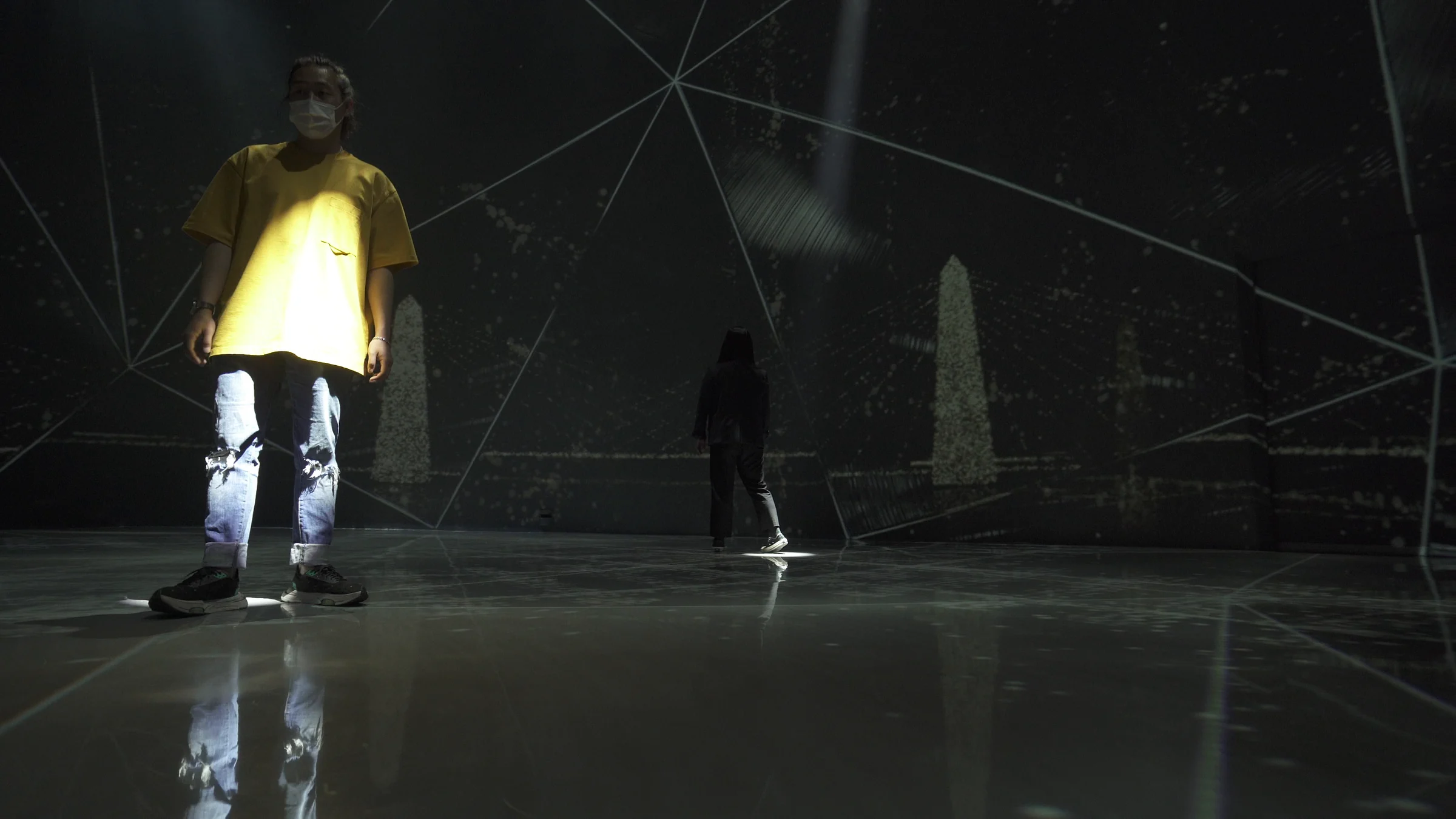 A visitor in yellow revealed by the light beneath them