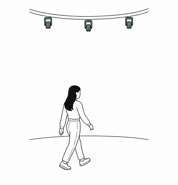 Visitors entering a broad circular floor beneath unlit ceiling fixtures