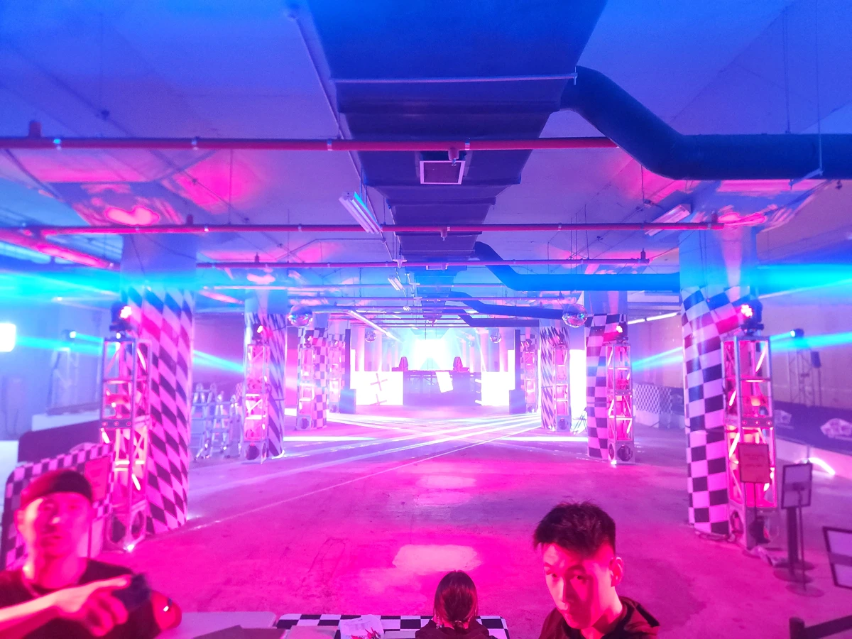 Teal lighting across columns and the audience area